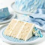 Slice of white coconut winter cake on a serving plate.