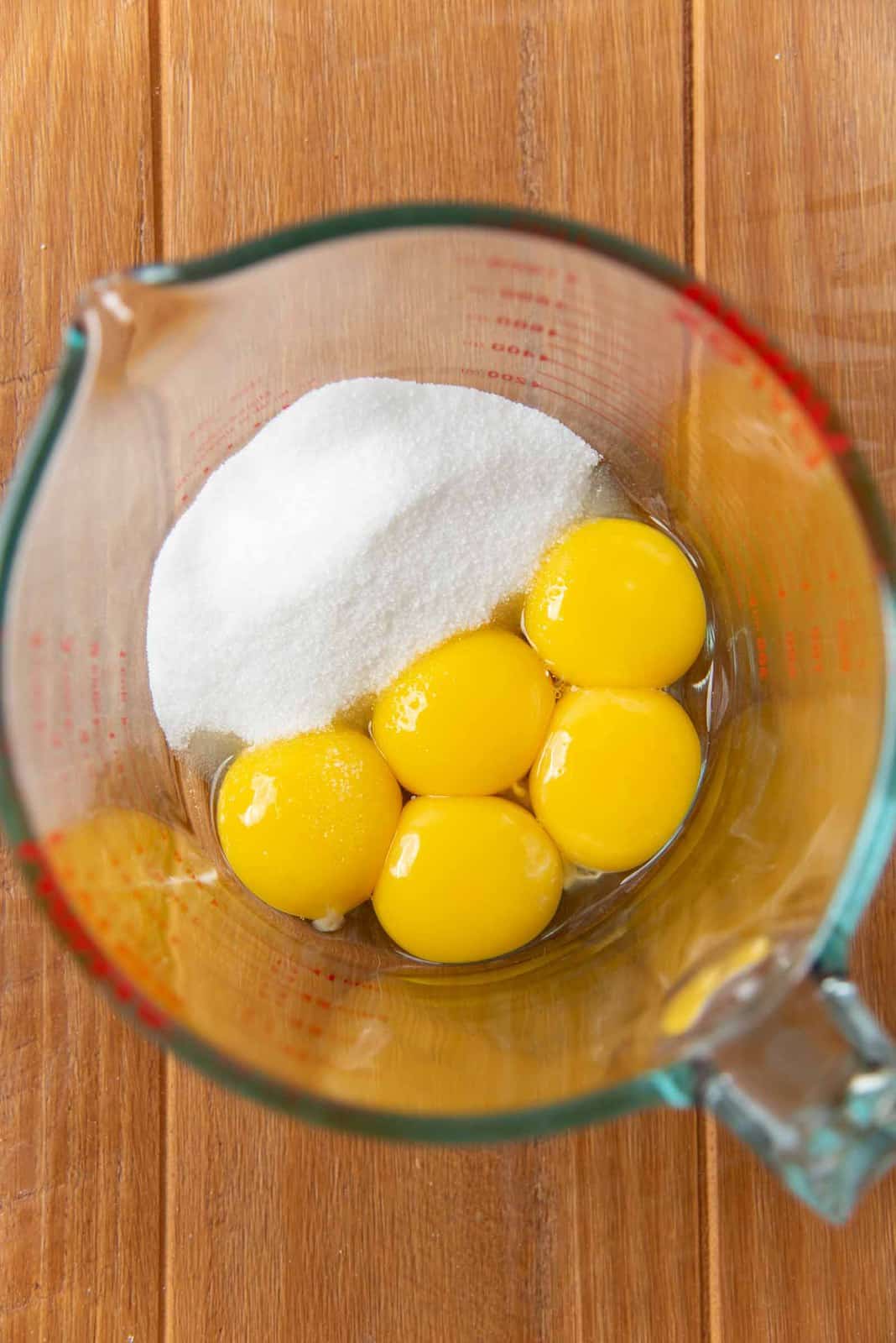 A large jug with egg yolks and sugar in it