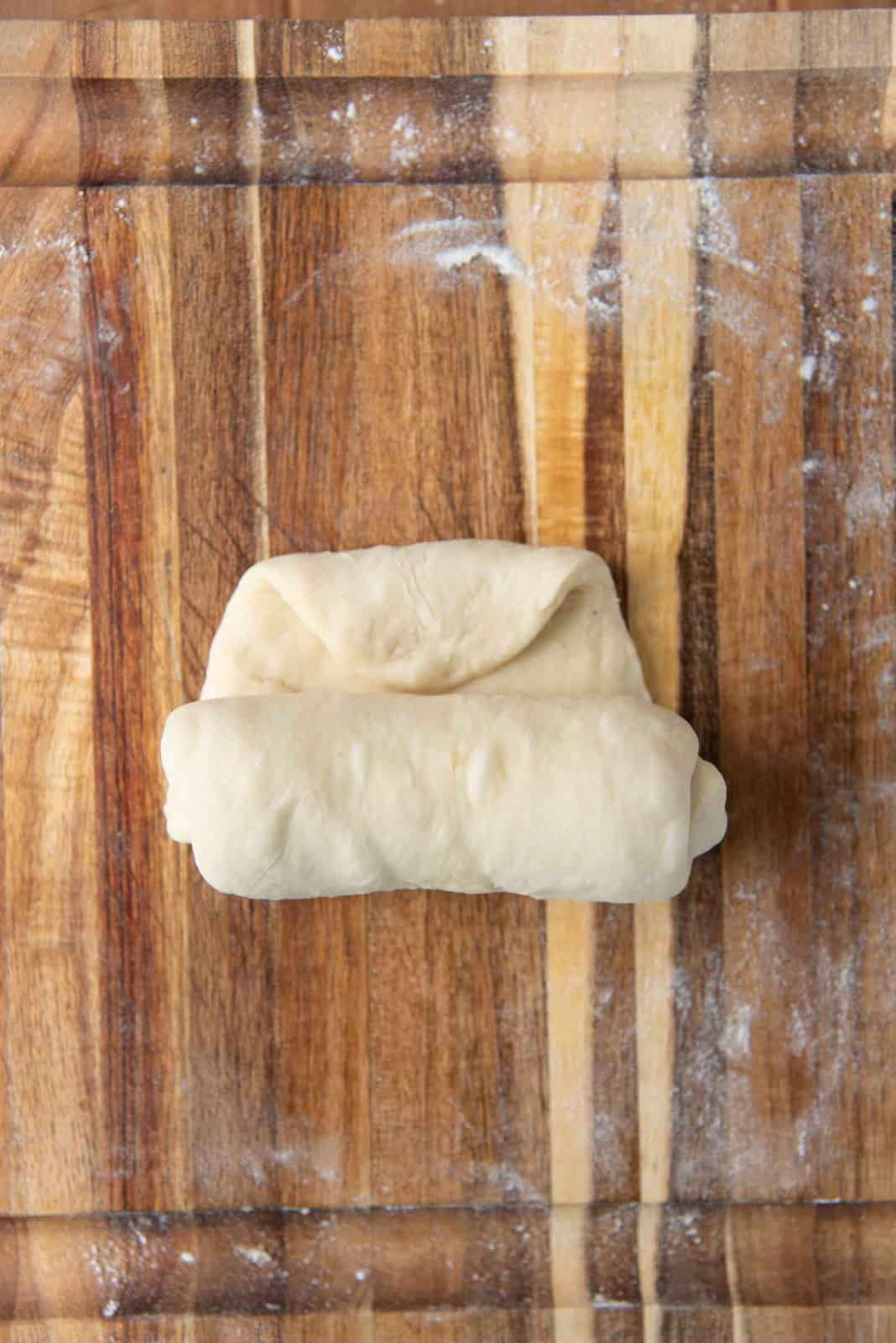 Shaping milk bread loaf - Roll up the dough, and fold in the edge.