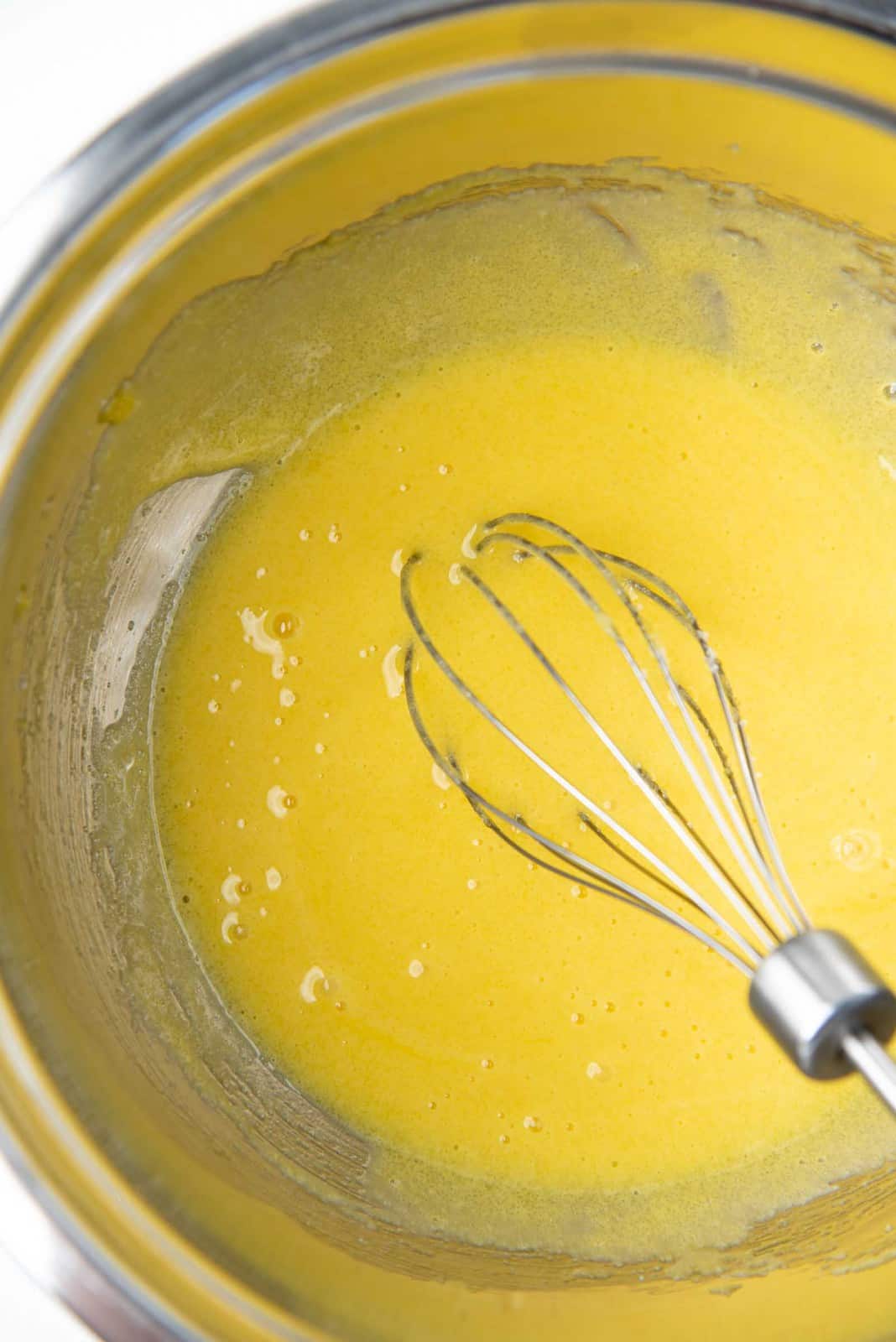 Egg yolk and sugar mixed together along with vanilla extract in a large bowl.