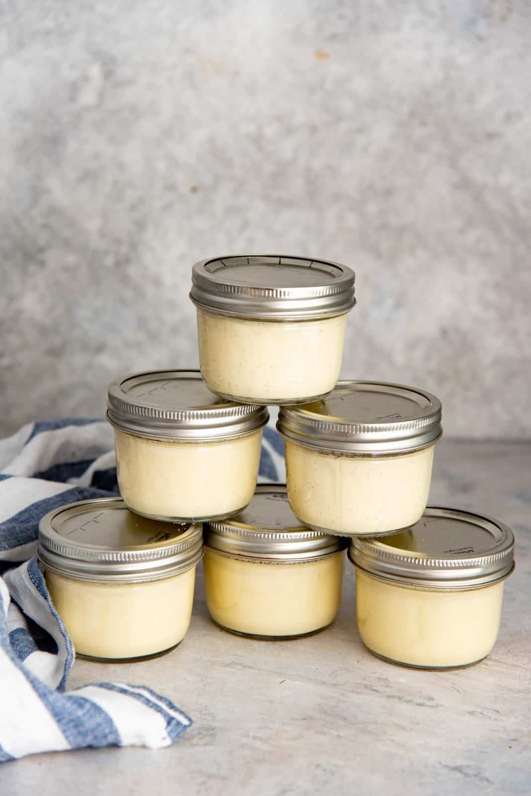 Cooked and chilled sous vide creme brulee mason jars stacked on top of each other.