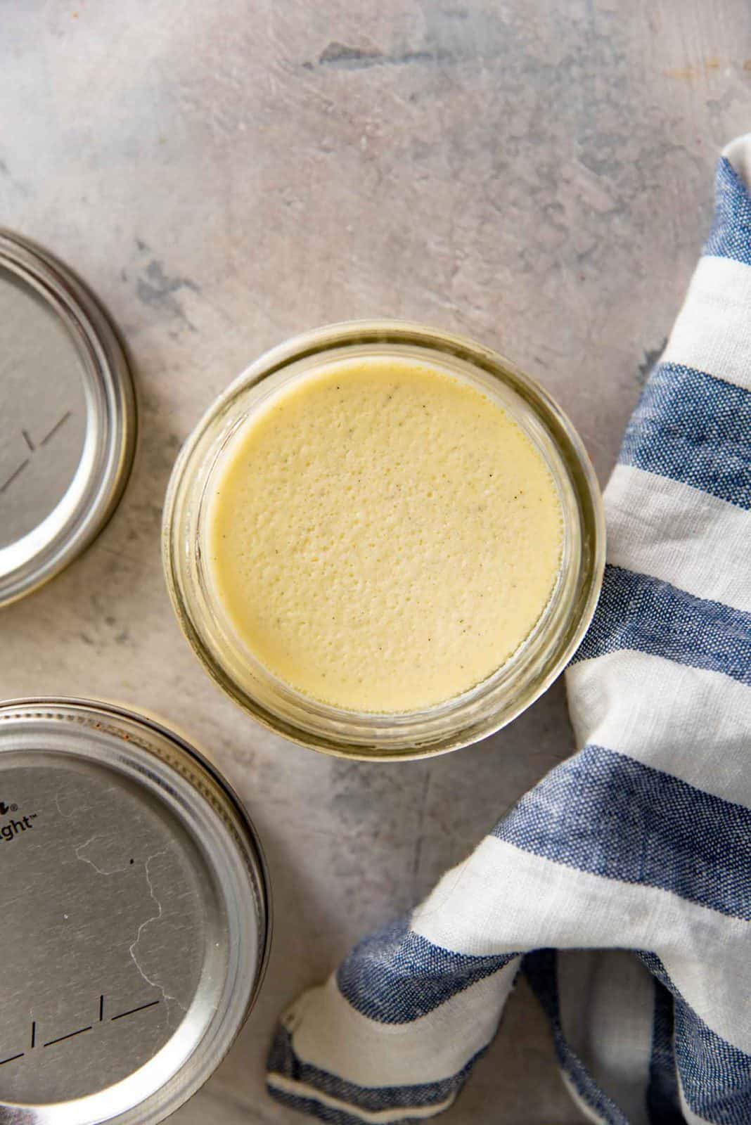 Top view of an open jar filled with creamy, cooked creme brulee custard.