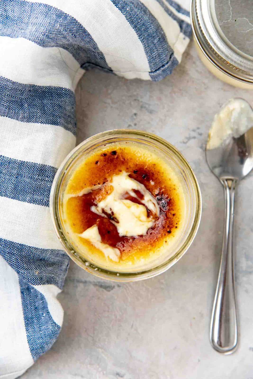 Creamy creme brulee underneath the broken golden brown caramel layer on top.