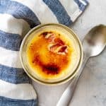 Overhead view of sous vide cream brulee in a small mason jar with the caramel layer cracked in one spot.