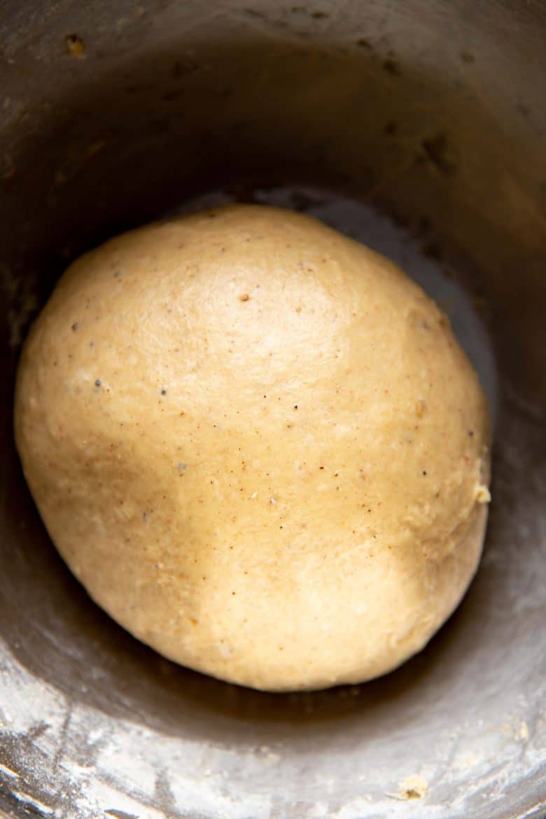 A smooth hot cross bun dough in a mixing bowl after kneading, before adding chocolate chips.
