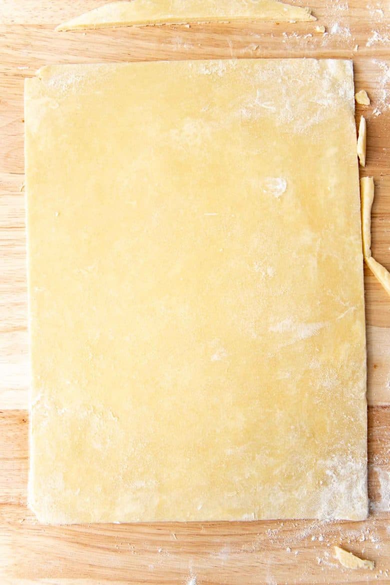 The pie dough rolled out to a rectangle on the work surface.