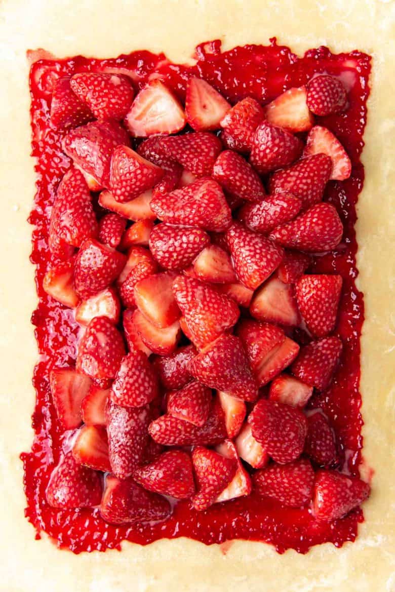 The strawberries piled on top of the pie crust.