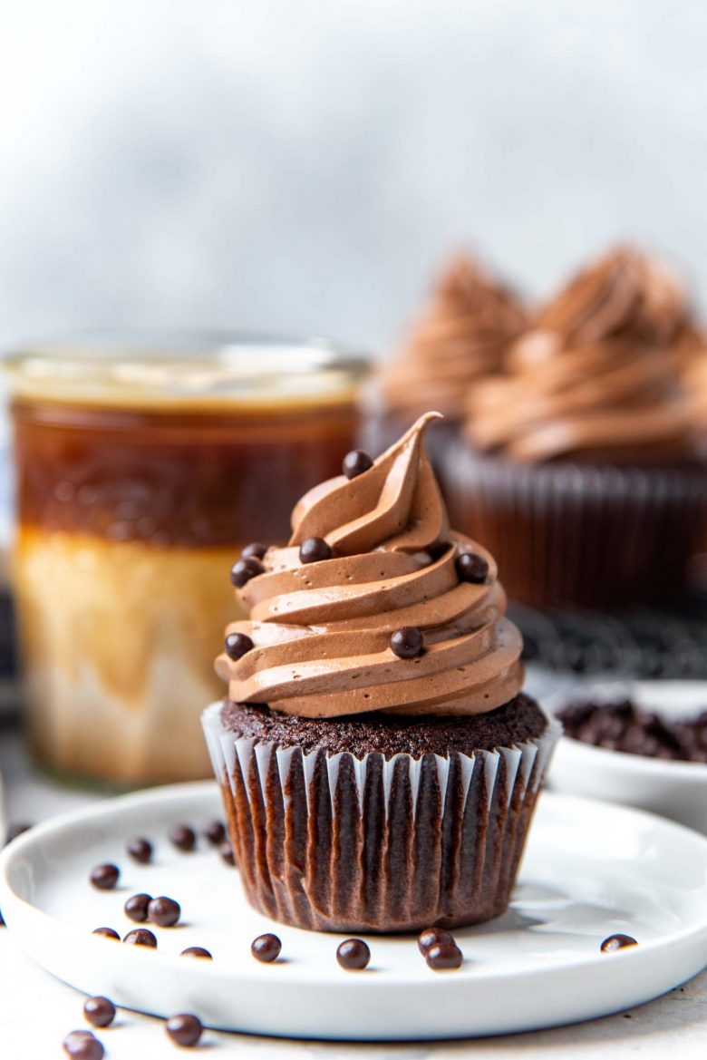 A cupcake topped with chocolate swiss meringue buttercream