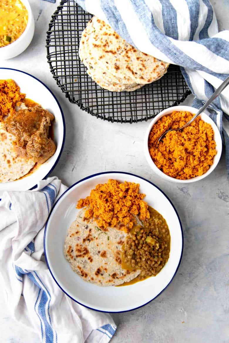 An overhead view of the Sri Lankan roti served on plates with side dishes