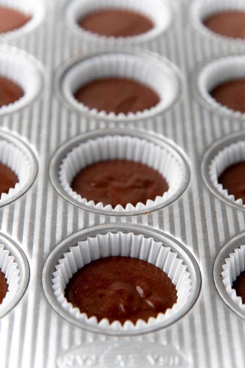 A view of the filled cupcake liners, with the chocolate cupcake batter