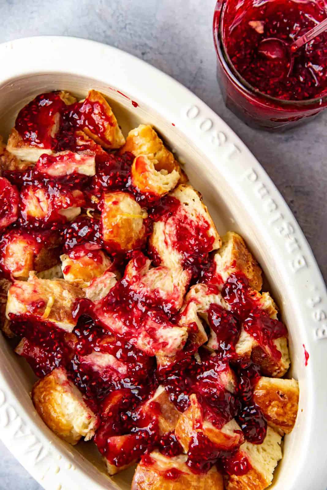 Some of the raspberry jam spread over the layer of custard soaked croissants.