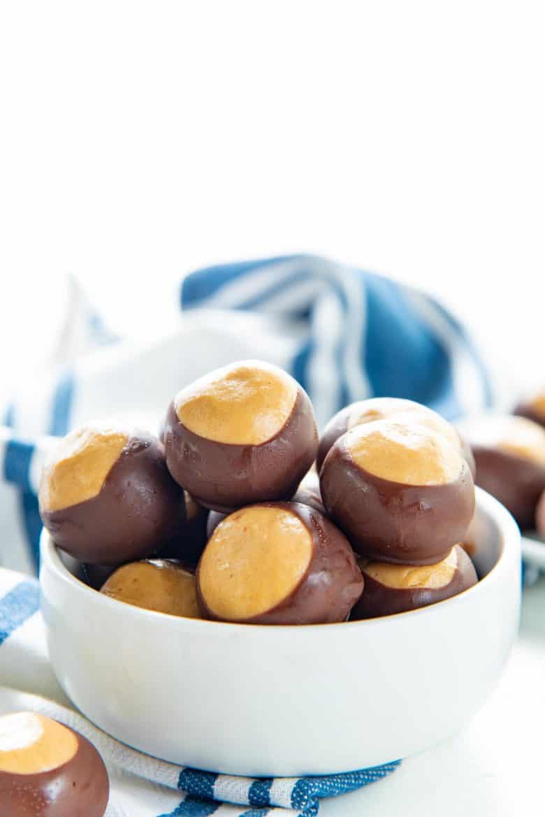 Peanut butter buckeyes in a white bowl on a tabletop