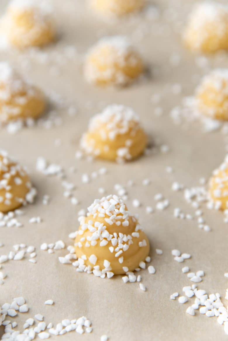 Choux pastry generously coated with pearl sugar, before baking
