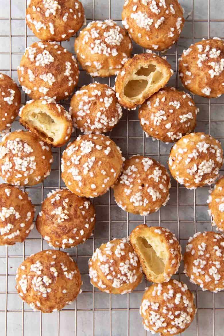 An overhead view of a batch of chouquettes on a wire rack