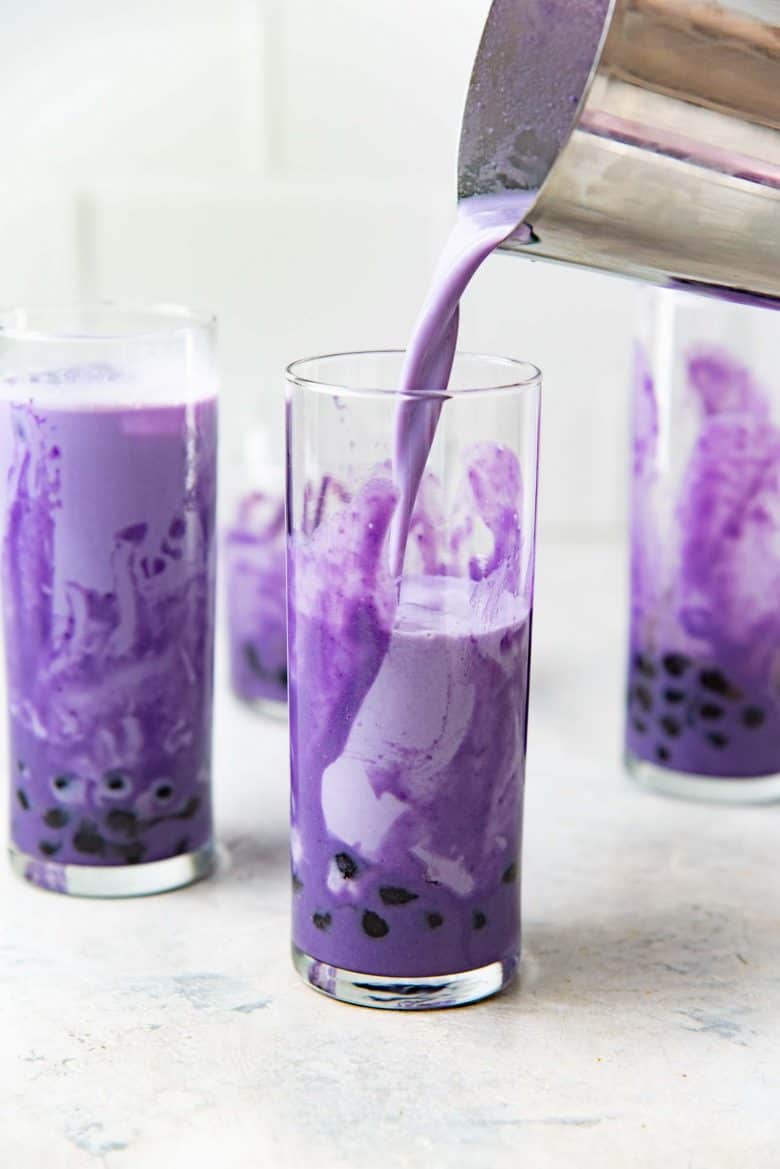 Pouring the blended ube milk into ube swirled glasses