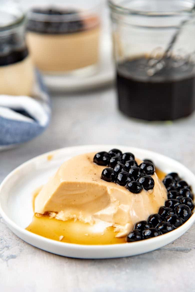 An image with a spoonful of panna cotta eaten, showing a silky smooth texture of bubble milk tea panna cotta