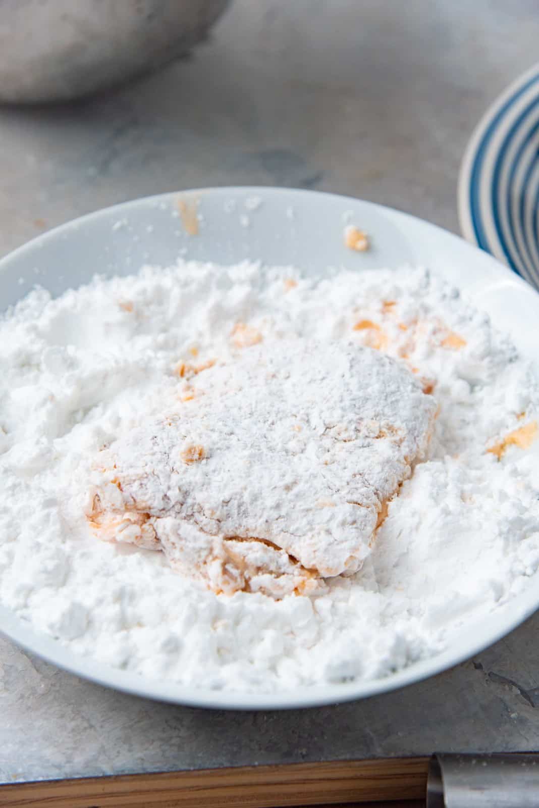 Coating a chicken thigh with potato starch