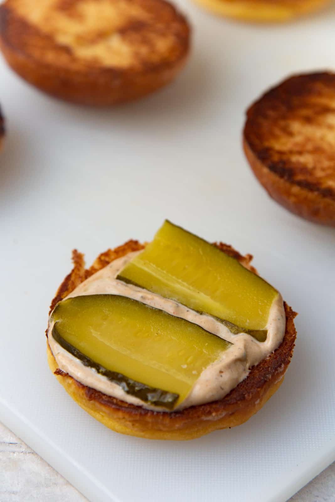 Pickles placed on top of the burger bun