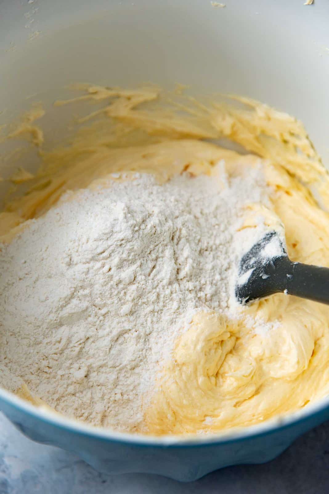 Cake batter in a bowl, with dry ingredients added on top