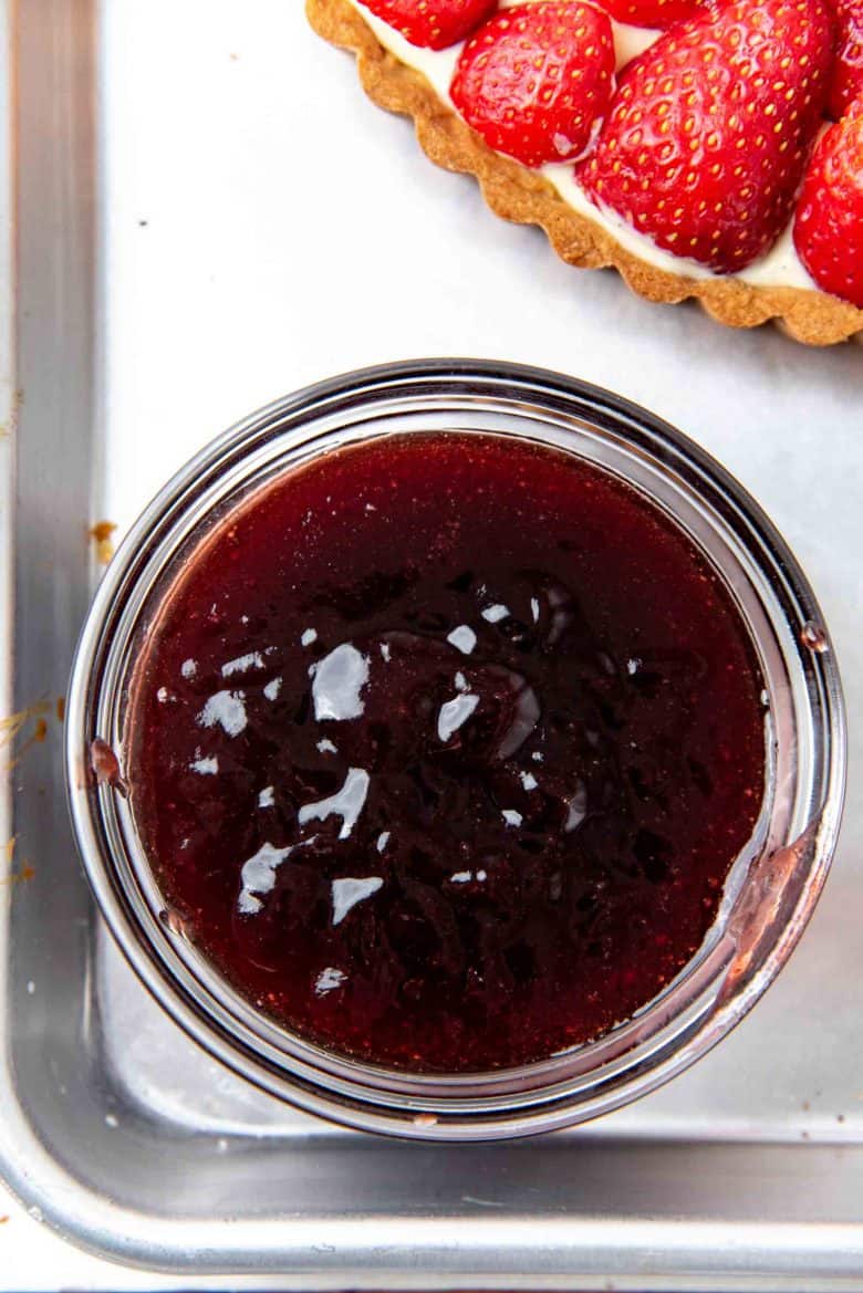 Berry jam in a bowl next to the tart
