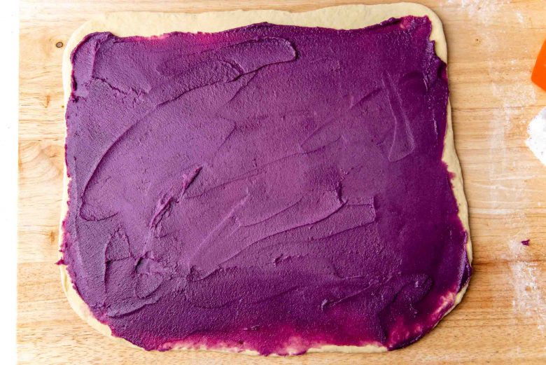 Ube jam spread out on the bread dough to be ube rolls