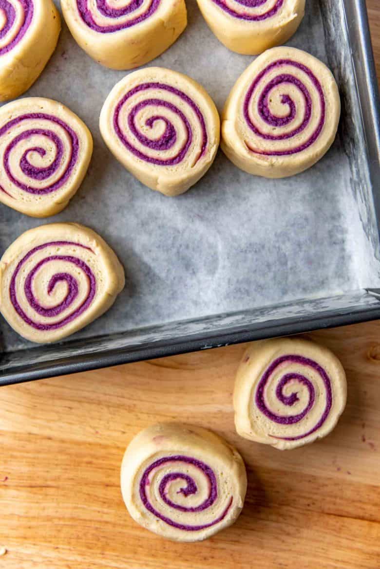 Placing the ube bread rolls in the prepared baking pan