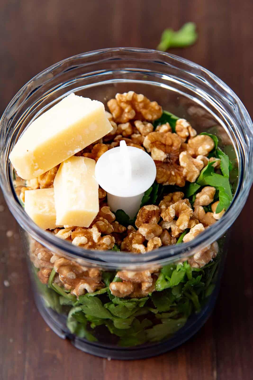 All the ingredients for the parsley pesto in a food processor.