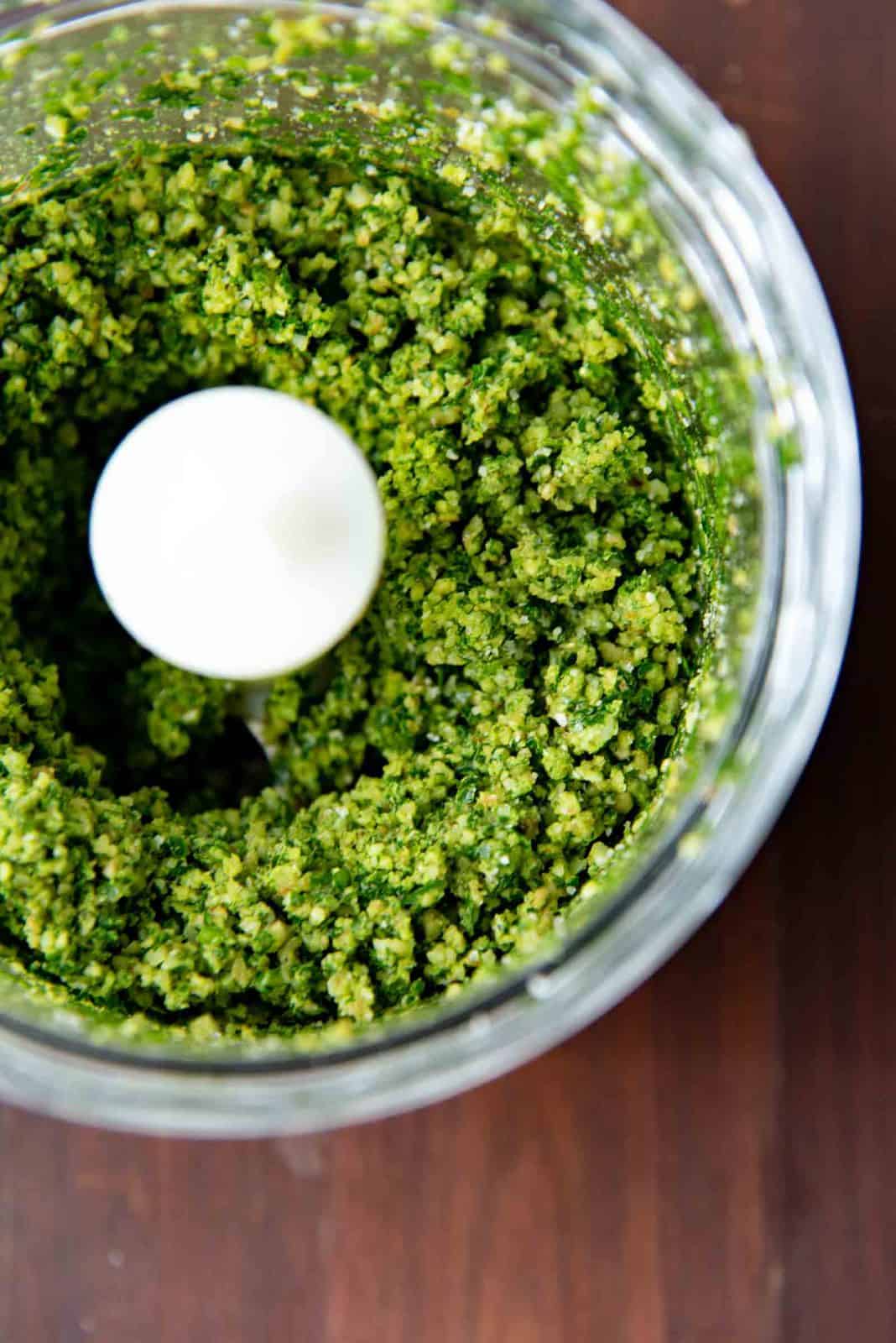 Finely minced walnut parsley pesto in the food processor bowl.