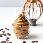 A tall swirl of easy chocolate Swiss meringue buttercream in a small glass jar.