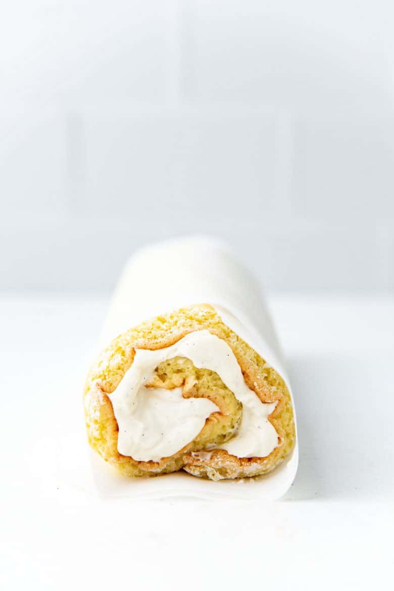 Vanilla swiss roll cake rolled up with whipped cream