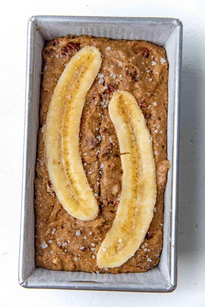 Banana halves pressed into the top of the banana bread batter
