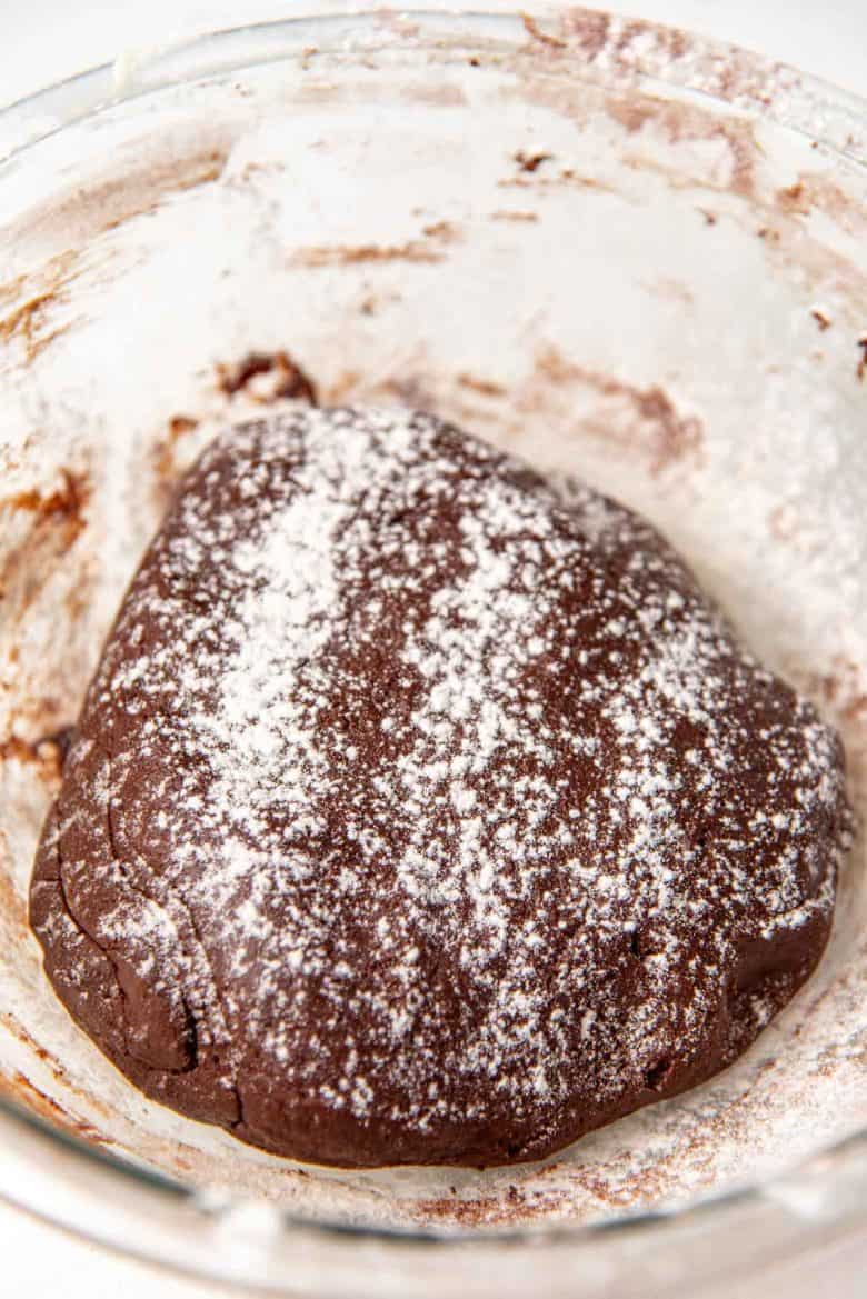 A lightly floured chocolate pate sucree dough in a bowl