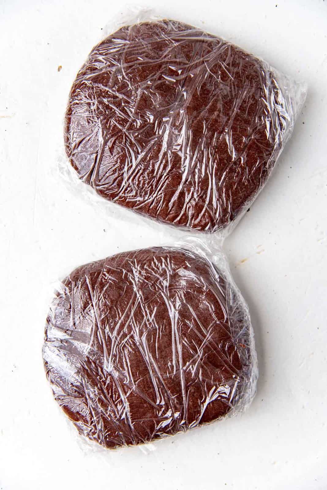 The dough divided into two and wrapped with plastic wrap