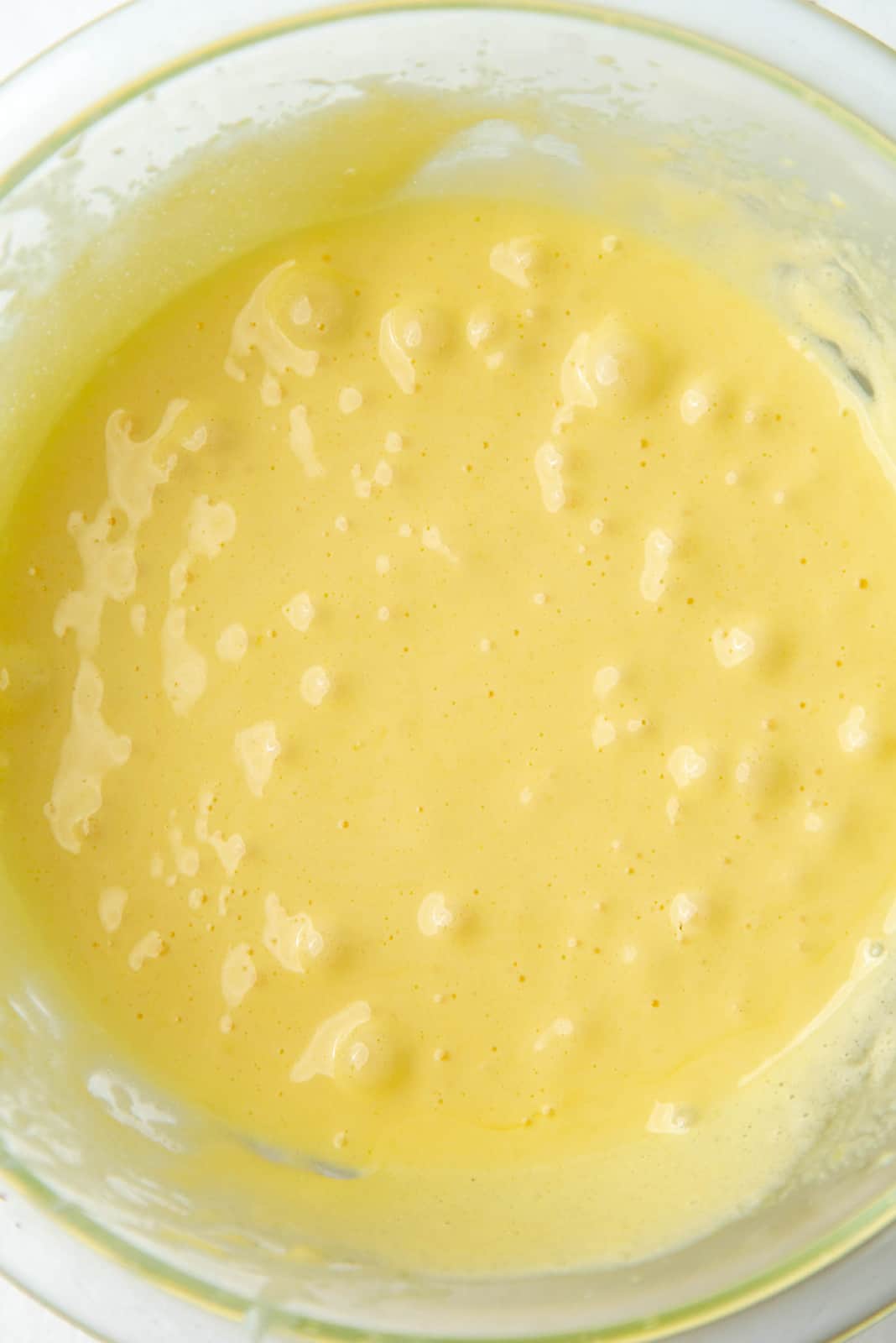 Yolks and sugar mixed until pale and thick in a glass bowl.