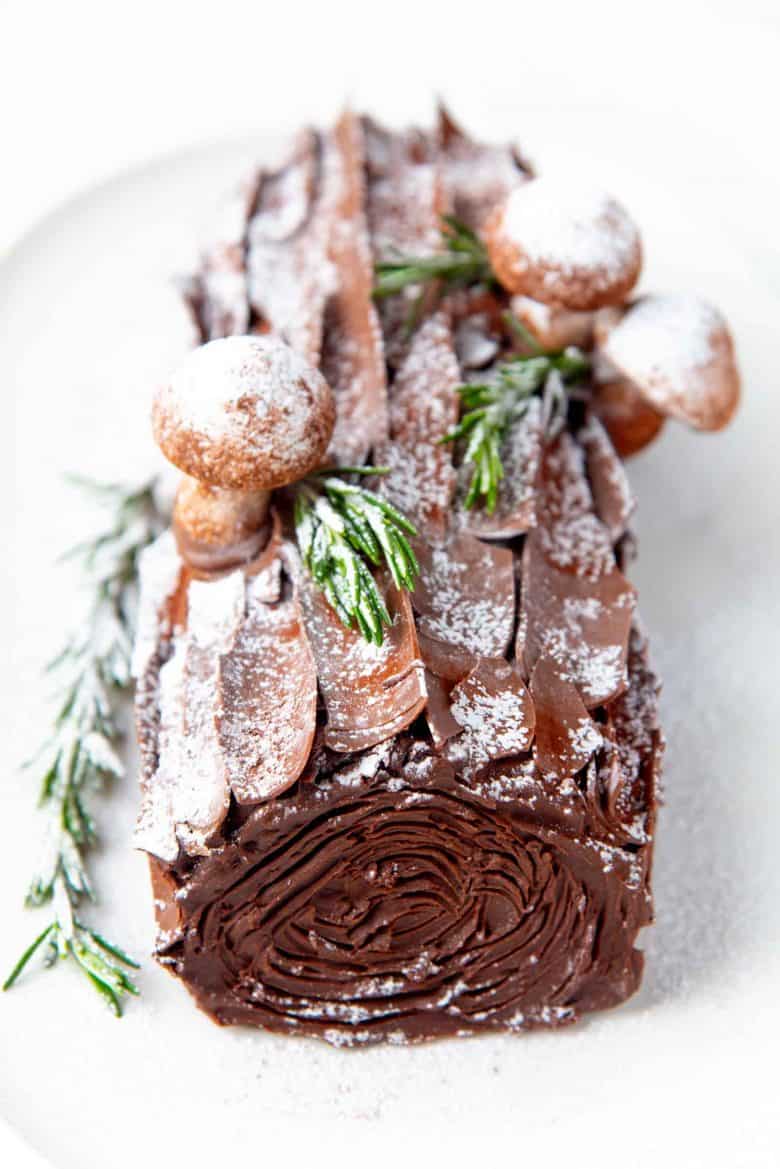 A close up of the buche de noel covered with chocolate shards, confectioner's sugar