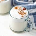 Homemade vanilla steamer topped with cinnamon in a glass mug.