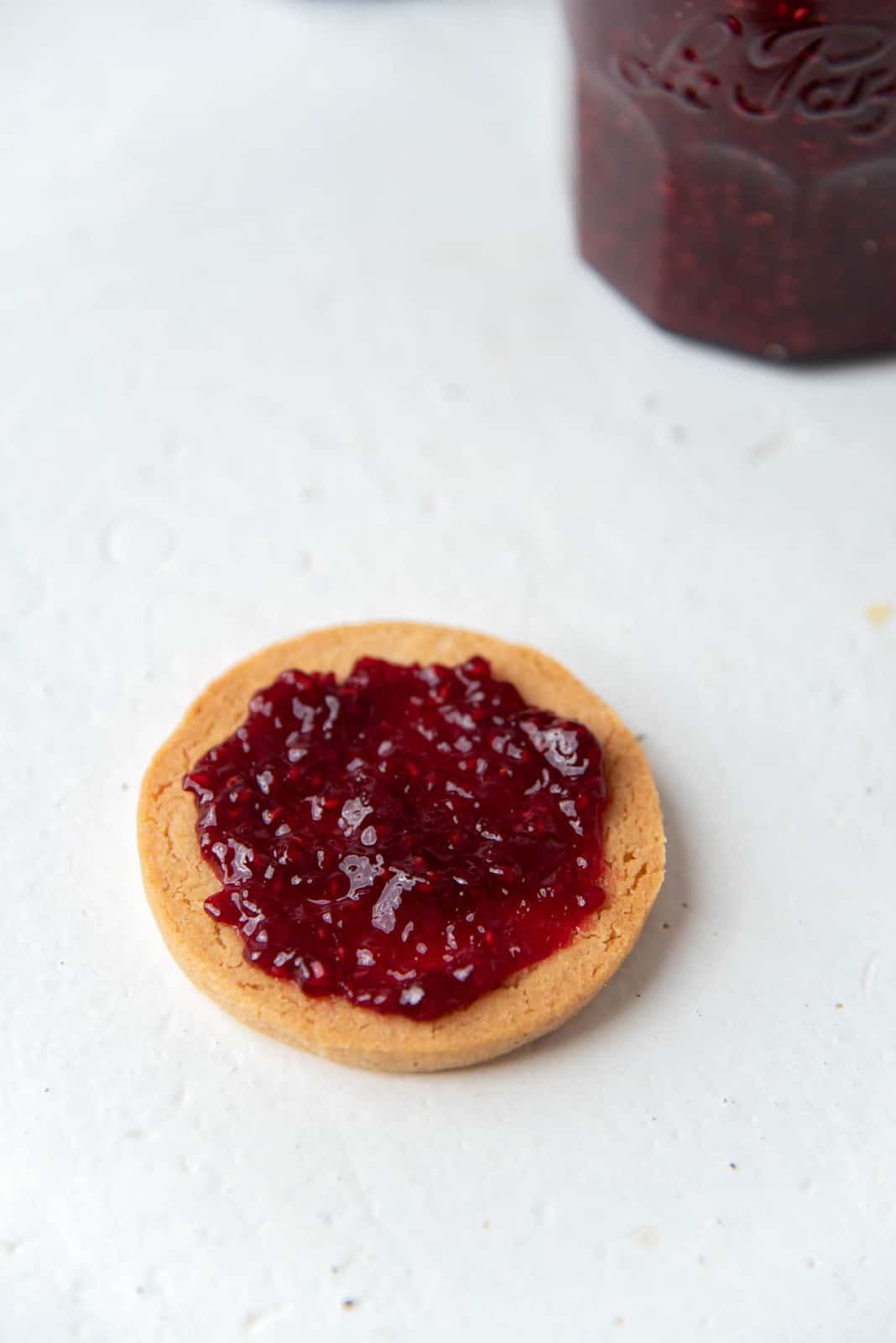 Spreading a dollop of the jam on a linzer cookie