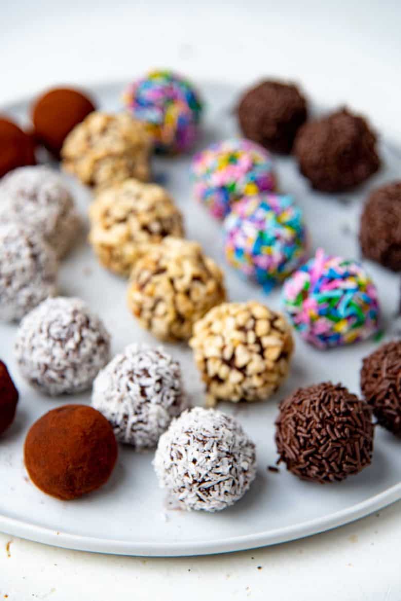Chocolate truffles coated in various toppings on a white plate