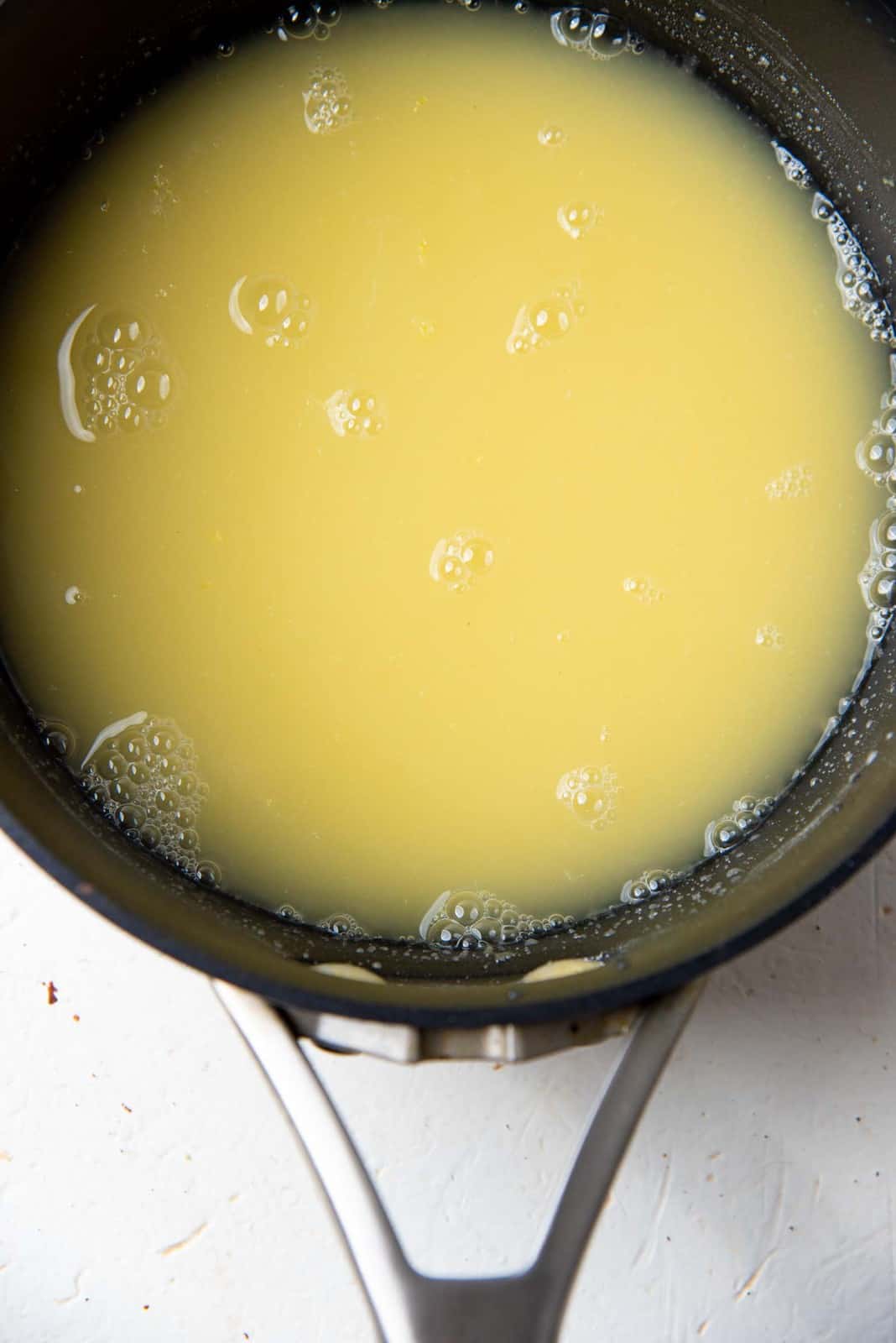 Cooked cornstarch mixture for lemon curd topping in a saucepan.