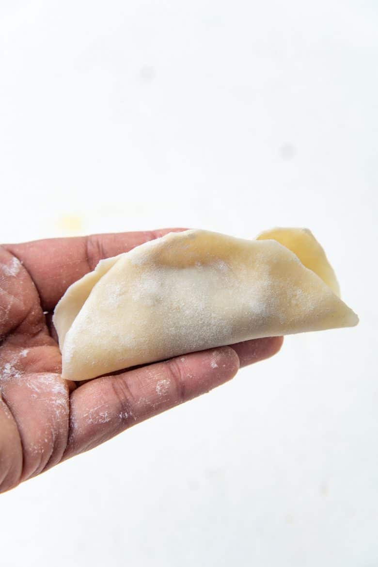 Dumpling wrapper folded over and sealed in the middle
