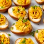 Asian deviled eggs topped with togarashi seasoning and spring onions.