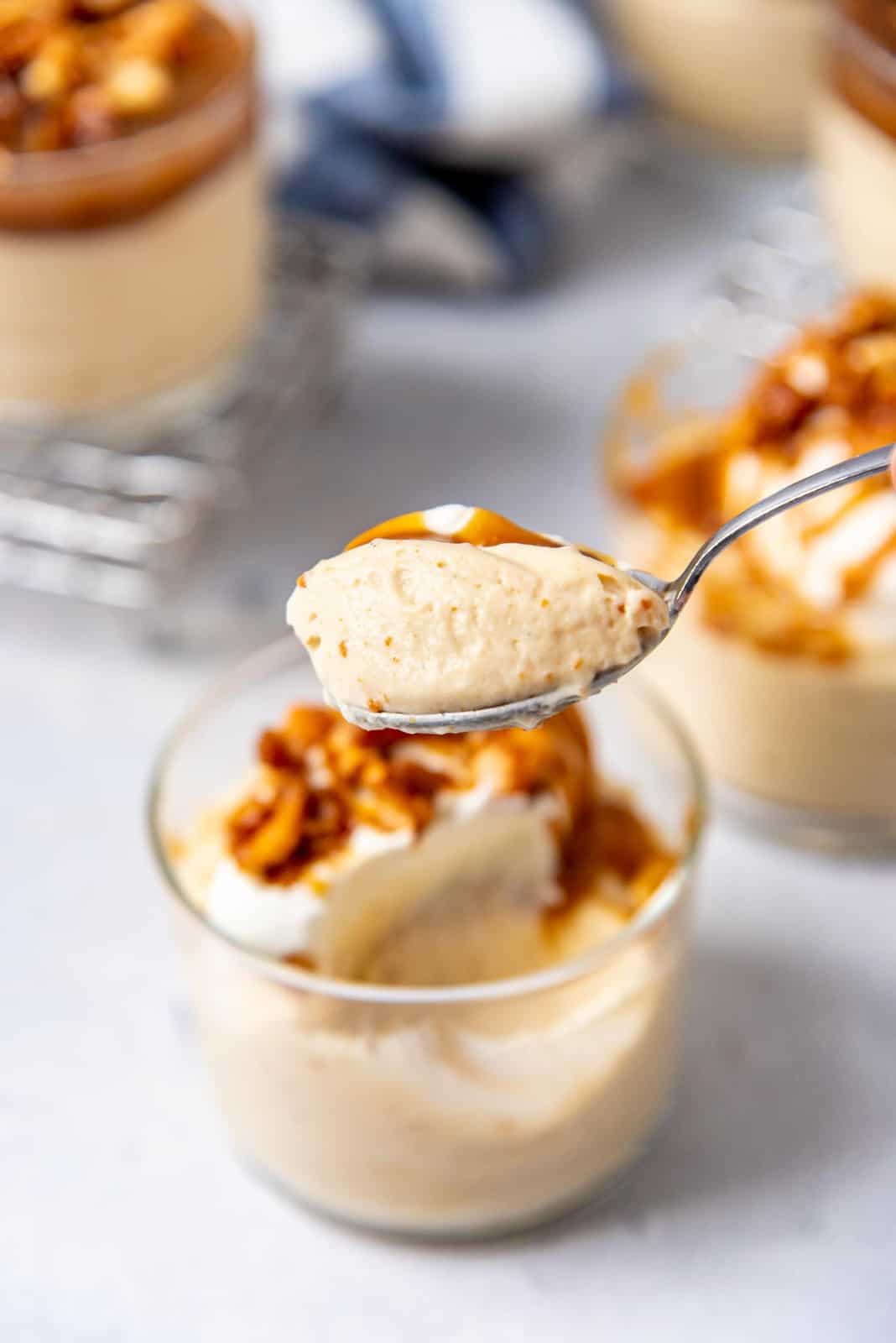 A spoonful of mousse in a spoon, held above serving bowl