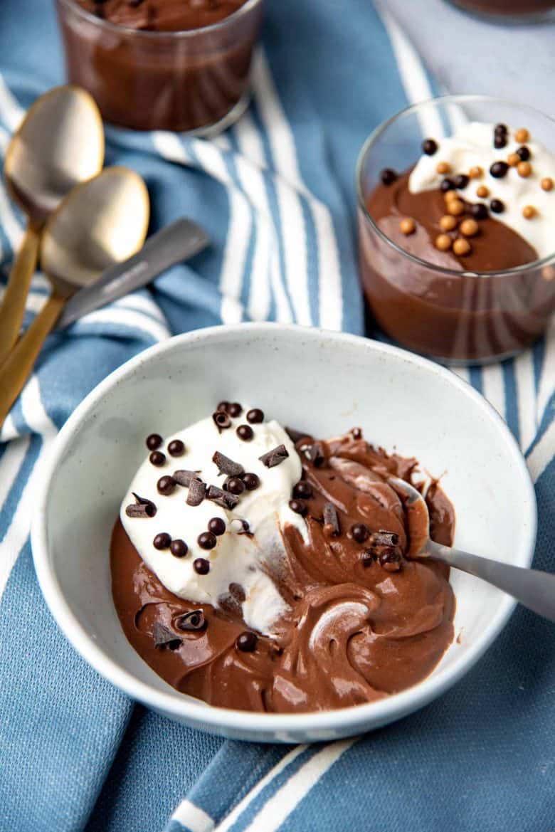 Pudding and whipped cream swirled together to show the creamy texture of the chocolate pudding