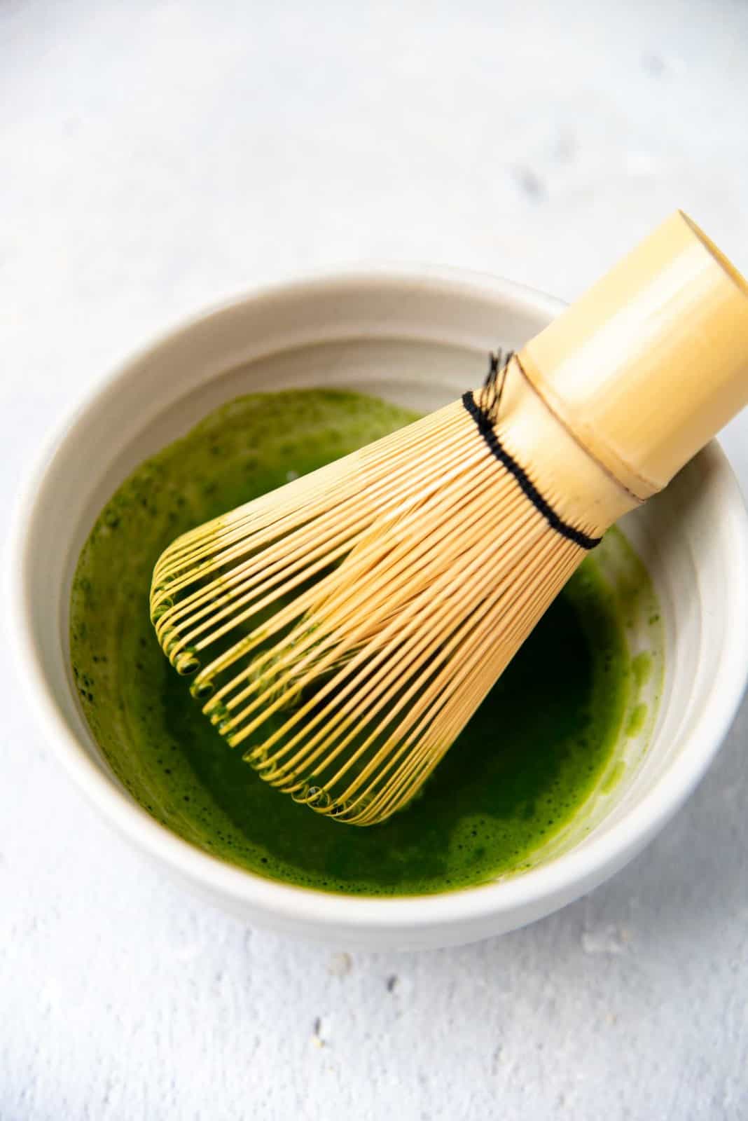 Whisking matcha with a bamboo whisk