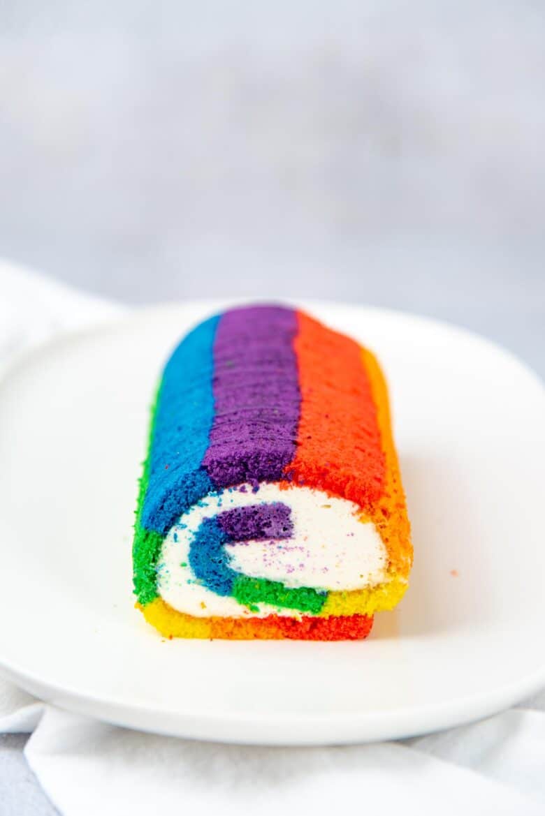 Rainbow swiss roll cake on a white plate