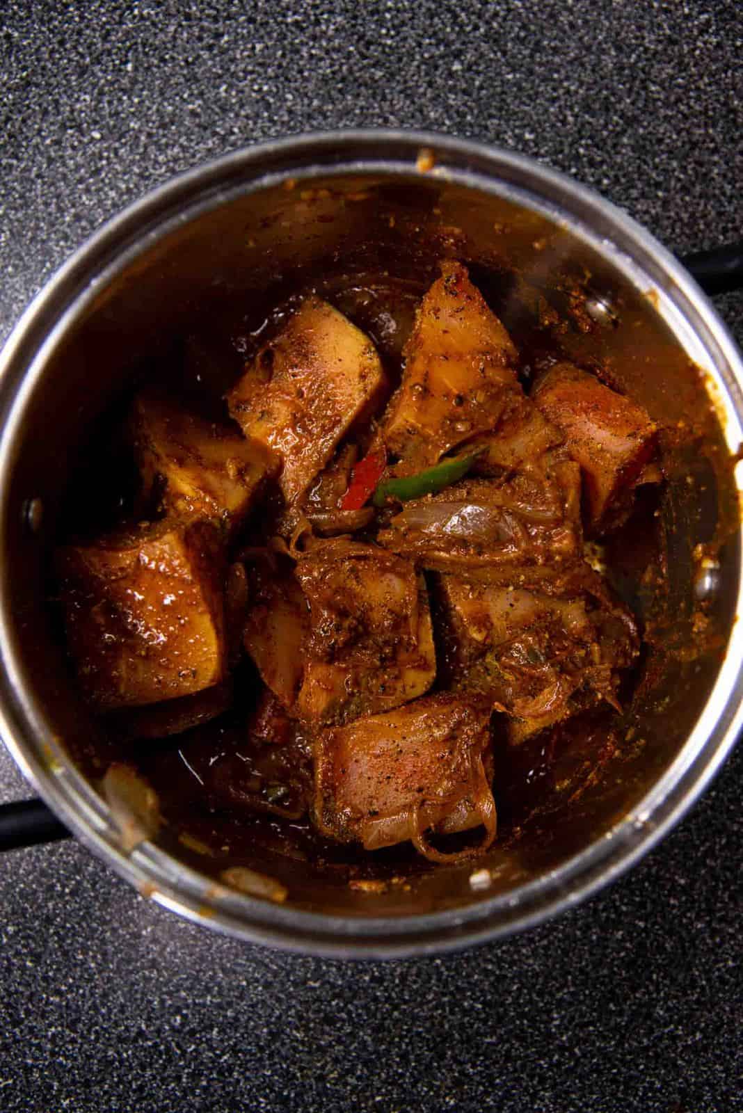 Adding the marinated fish into the pot, and mixed through to coat