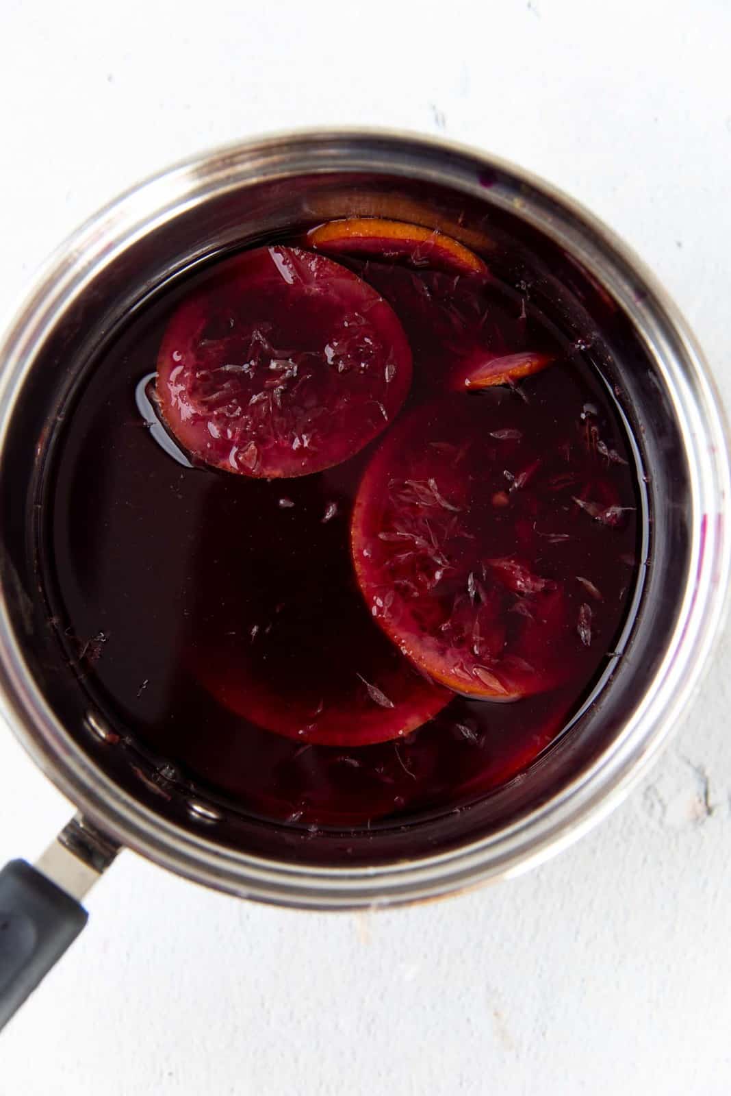 Mulled wine in a saucepan with orange slices and spices