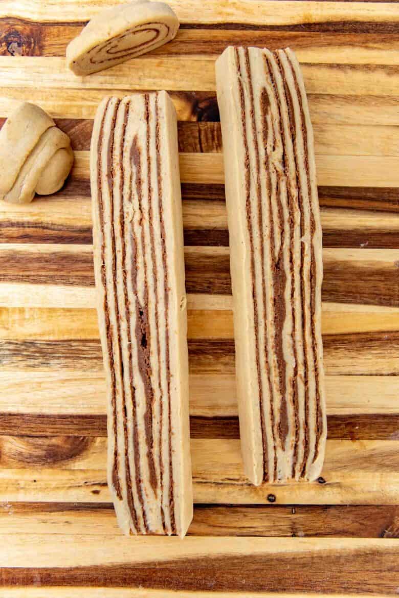 The bread roll cut in half lengthways on a cutting board