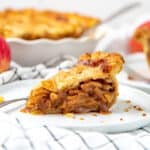 A square image of an apple pie slice on a plate.