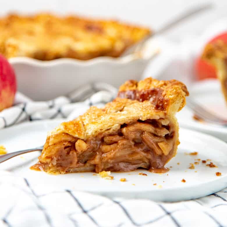 A square image of an apple pie slice on a plate.
